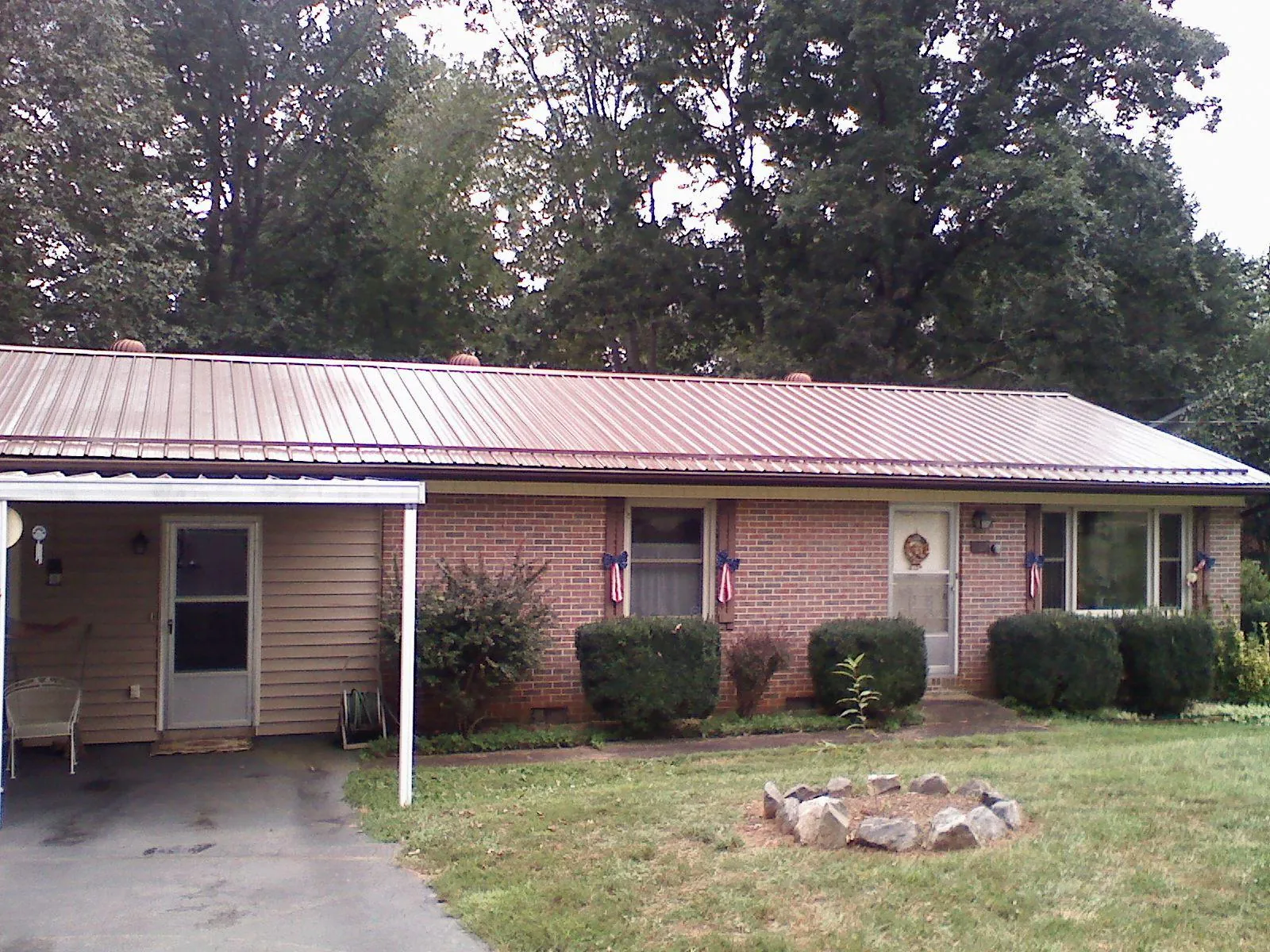 Bronze metal roof and carport on a brick ranch home — Roof Repair work by our crew in Andrew