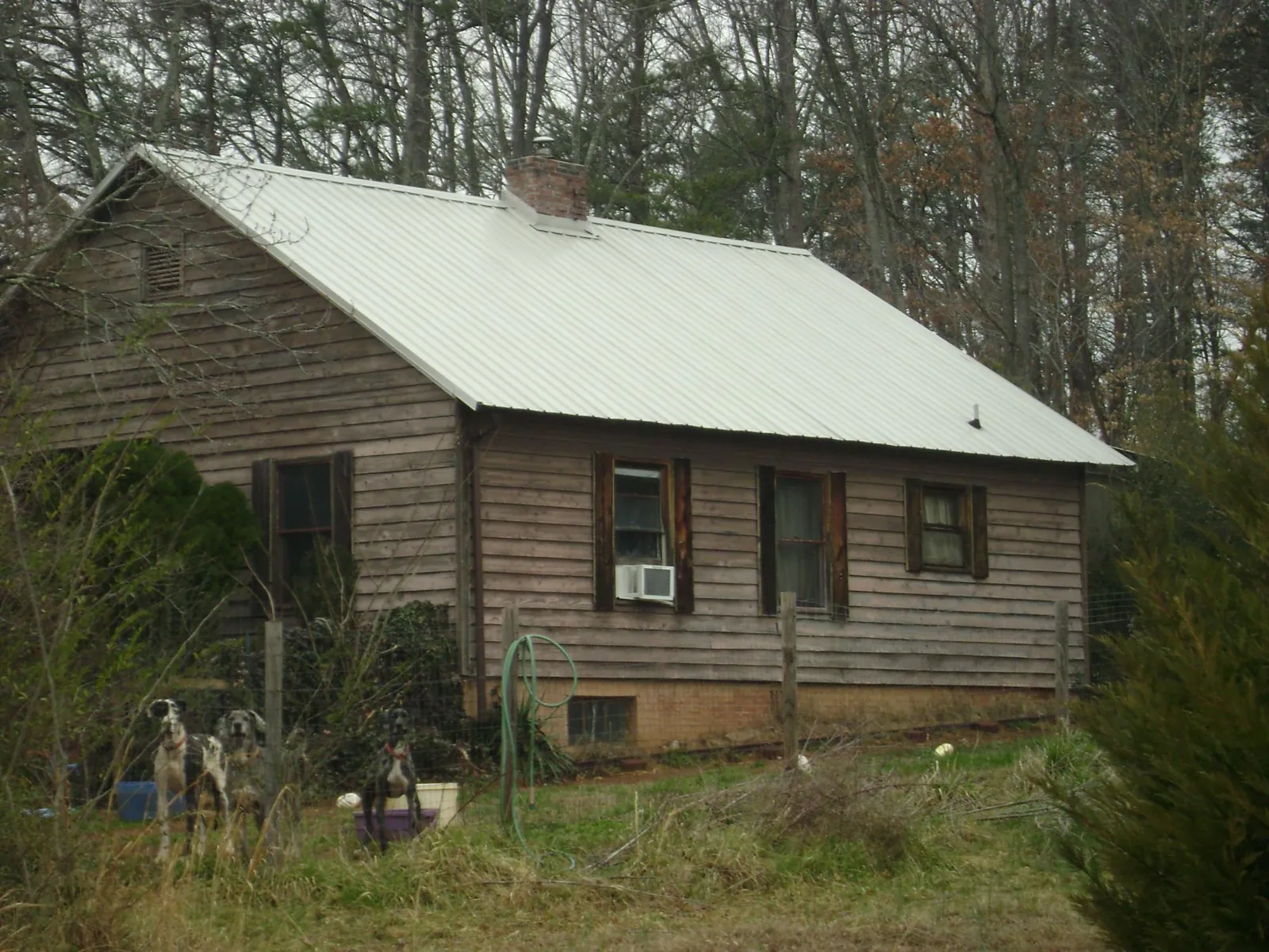 White metal roof on an old wood sided farmhouse, from a Metal Roof Installation job in Andrew